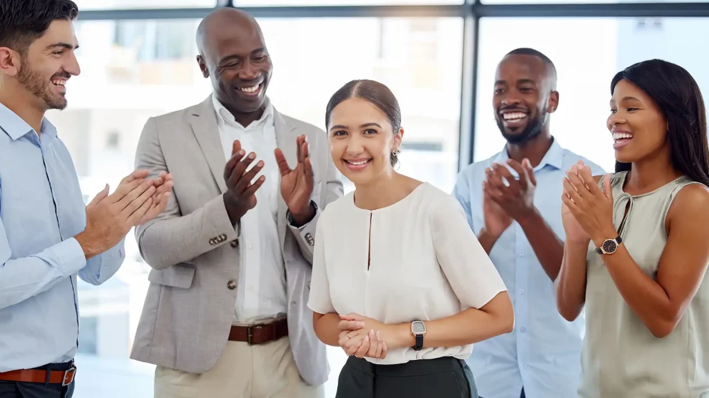 Équipe de travail célébrant une réussite collective, illustrant la reconnaissance professionnelle et la mobilisation des employés.