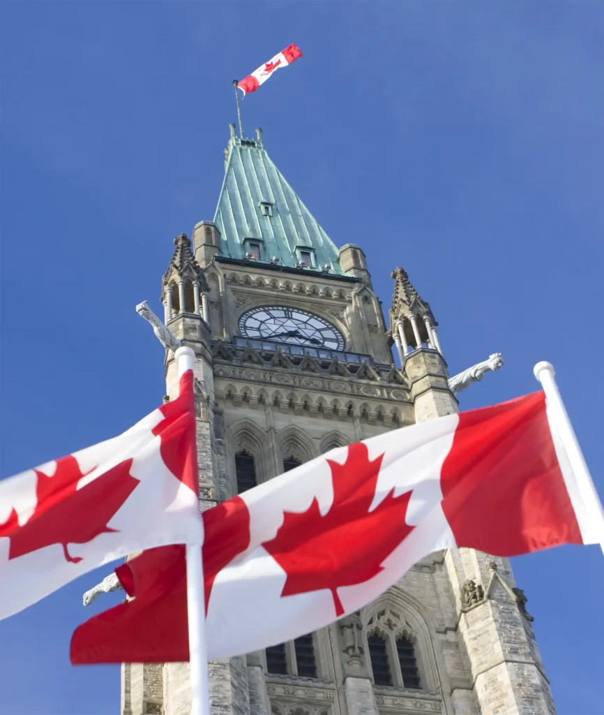 Drapeaux canadiens devant la Colline du Parlement à Ottawa.